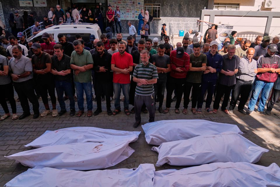 Palestinians pray over the bodies of people who were killed in an Israeli military strike on Sunday, during their funeral at Awda Hospital, in Nuseirat, in the central Gaza Strip, Monday, Oct. 20, 2025. (AP Photo/Abdel Kareem Hana)